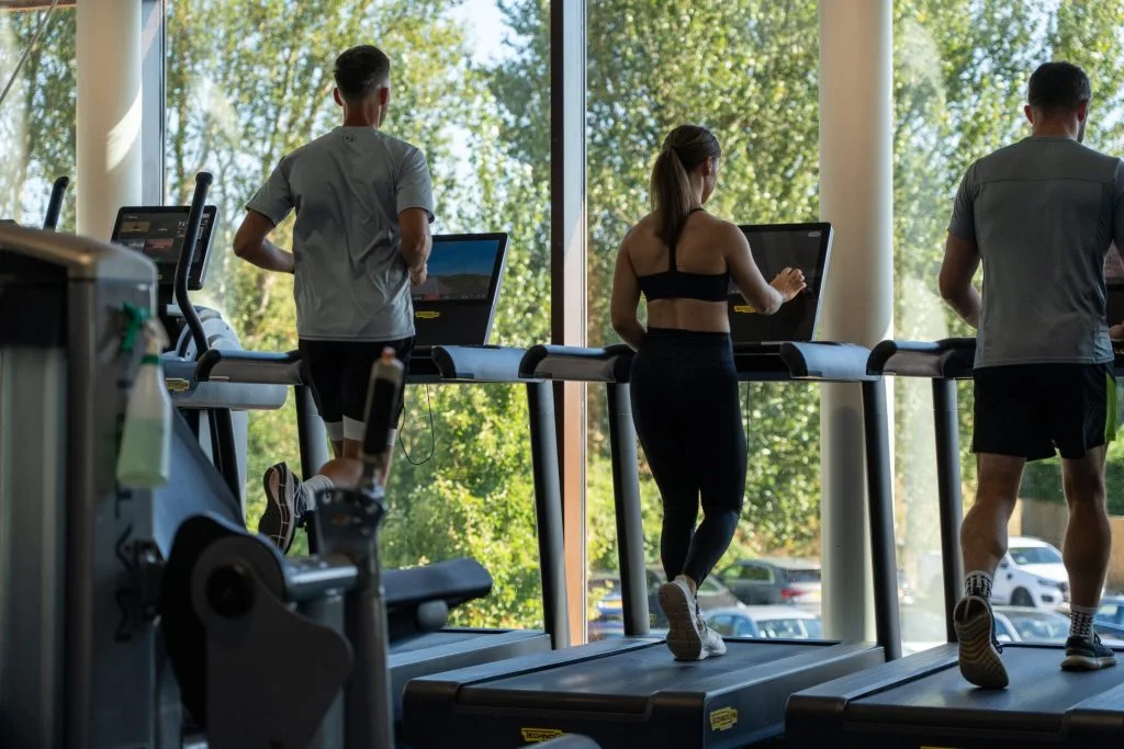 Three people on treadmills looking out at the view while exercising