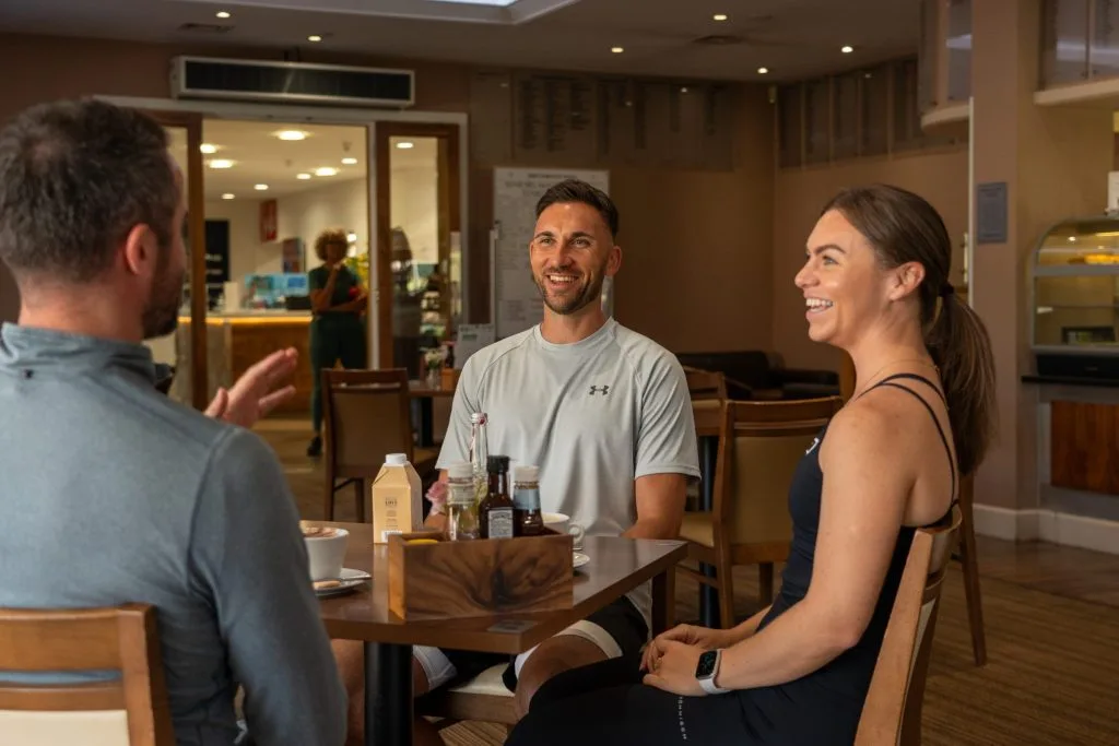 Three people sitting at table socialising in bar in dartford