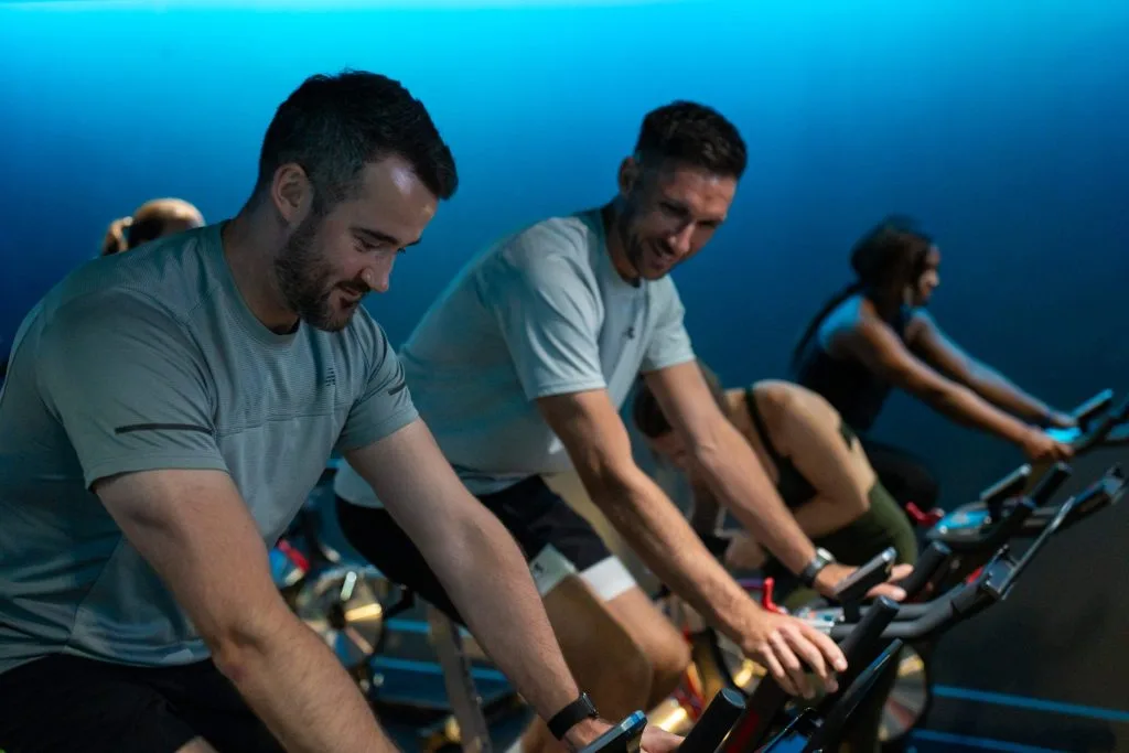 Three people on spin bikes in a spin class at gym in Dartford