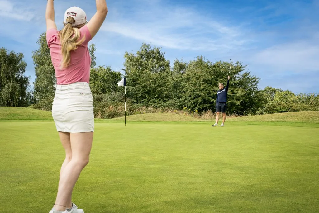Woman celebrating a golf shot on the green