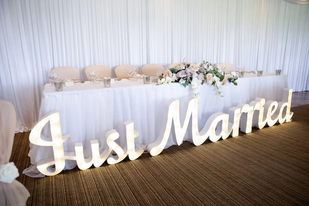 Wedding reception decorations and top table with wall draping and centre pieces