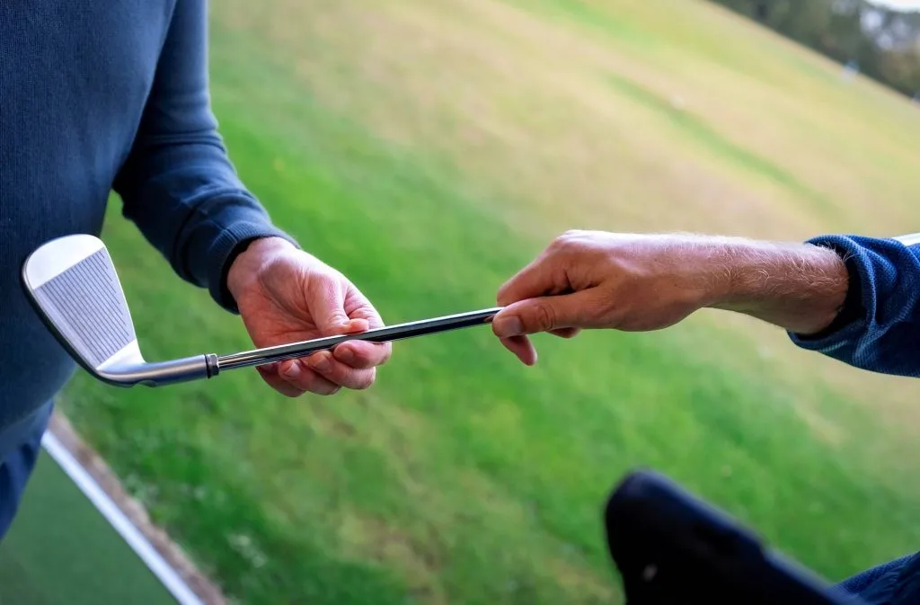 Two people holding a golf club during a custom fit session in kent